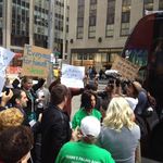The press and rally attendees meet the Occupy protesters holding controversial signs